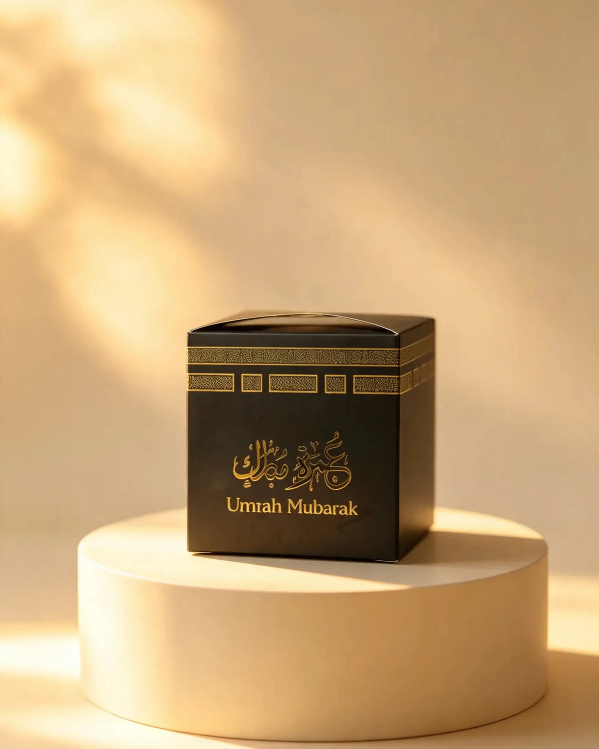 Small black Umrah Mubarak gift box with gold foil detailing on a pedestal