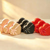 Nested heart-shaped glitter gift boxes in gold, black, and red, each tied with a satin ribbon bow