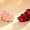 Pink heart-shaped nested gift boxes with satin bows, red boxes visible alongside