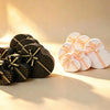 Pink and black heart-shaped gift boxes with ribbon bows grouped together on a tabletop