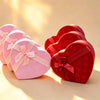 Set of three graduated heart-shaped gift boxes in pink and red with satin ribbon bows