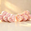 Heart-shaped gift boxes in pink and peach, each tied with a satin ribbon bow, shown together.