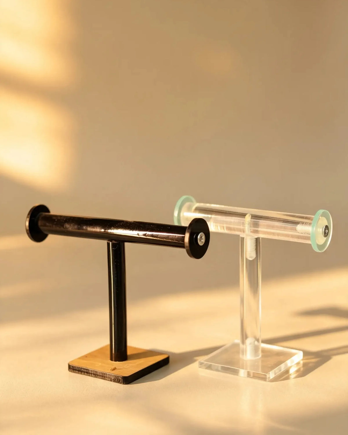 Clear acrylic T-bar bangle stand with mint end caps, shown beside a black metal T-bar stand