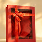 Red gift box with clear window, satin ribbon bow, and red fabric lining