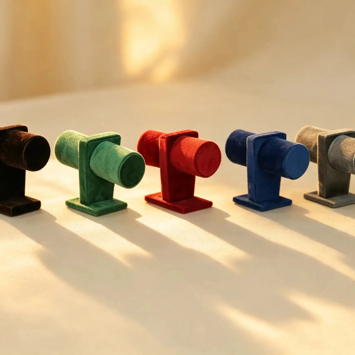 Five velvet bangle display stands in brown, green, red, blue, and grey