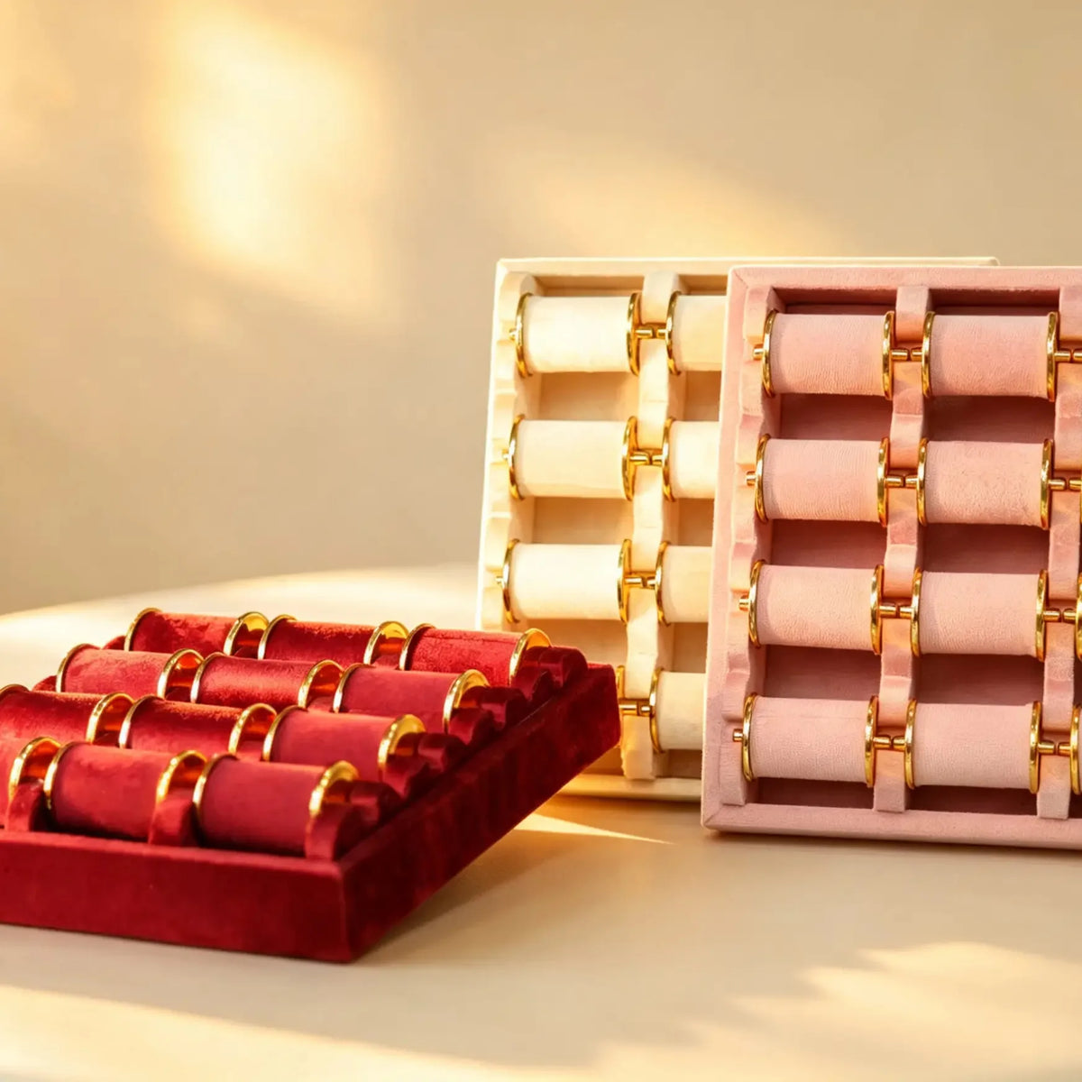 Cream, pink and burgundy velvet bangle display trays with gold-tone roll hardware