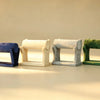 Four velvet bangle stands in navy, cream, grey, and green lined up side by side
