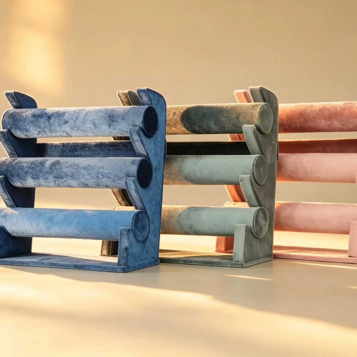 Three velvet bangle stands in blue, sage green, and pink, shown side by side
