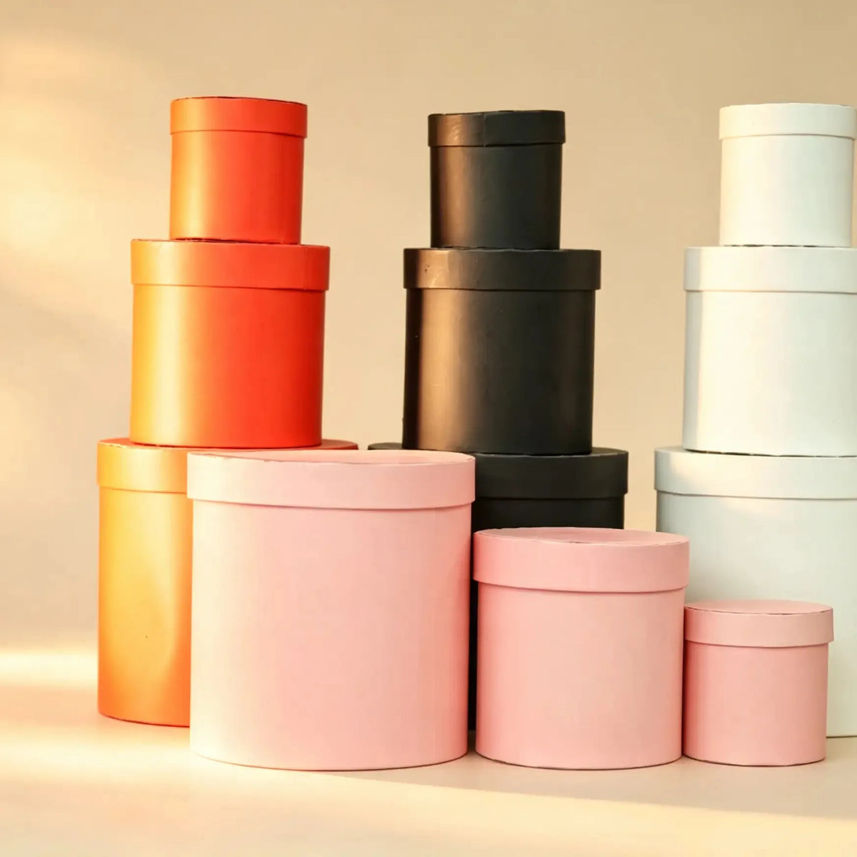 Red nested round gift boxes with lids, grouped with black, white, and pink sets