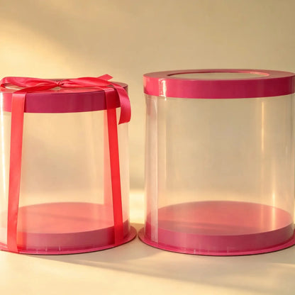 Pink and clear PVC cake box set, two nested sizes with a red ribbon bow
