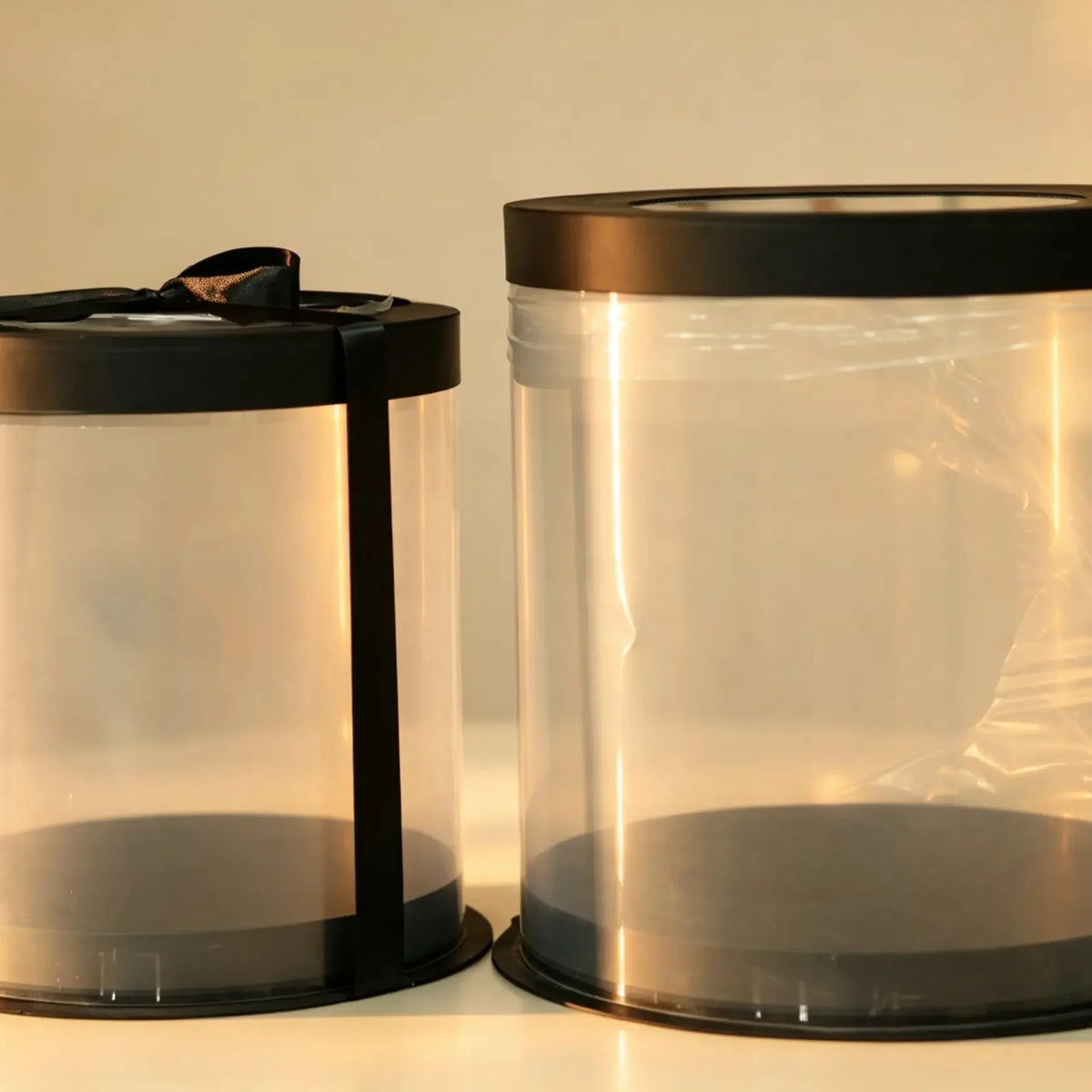 Black and clear PVC cake box set, two nested sizes, one tied with a black ribbon
