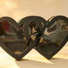 Black double-heart shaped gift box with clear window panels and a black ribbon bow