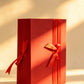 Red folding gift box with two red satin ribbon bows
