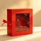 Red folding gift box with a clear front window and matching red ribbon bow