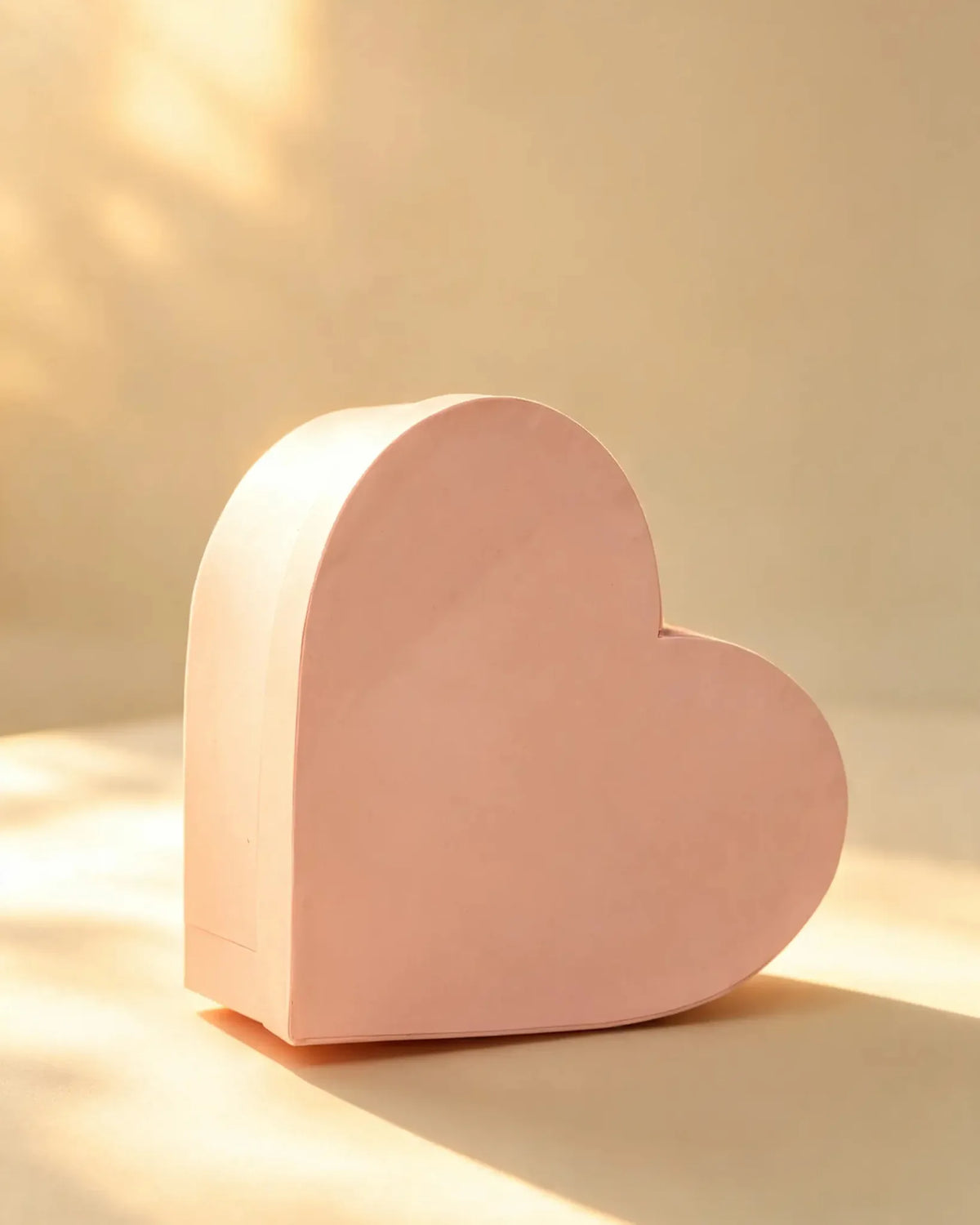 Blush pink heart-shaped cardboard gift box, front angled view