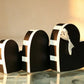 Nested set of three black heart-shaped gift boxes with a white trim band and cream ribbon bow on the largest box