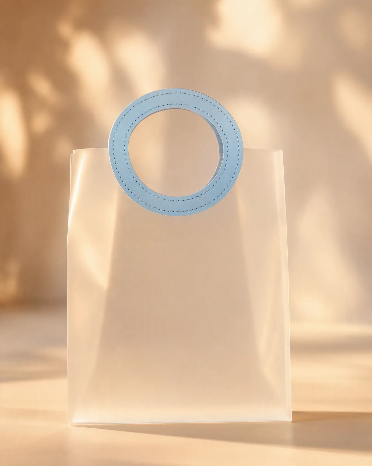 Frosted blue PVC gift bag with round stitched handle, front view