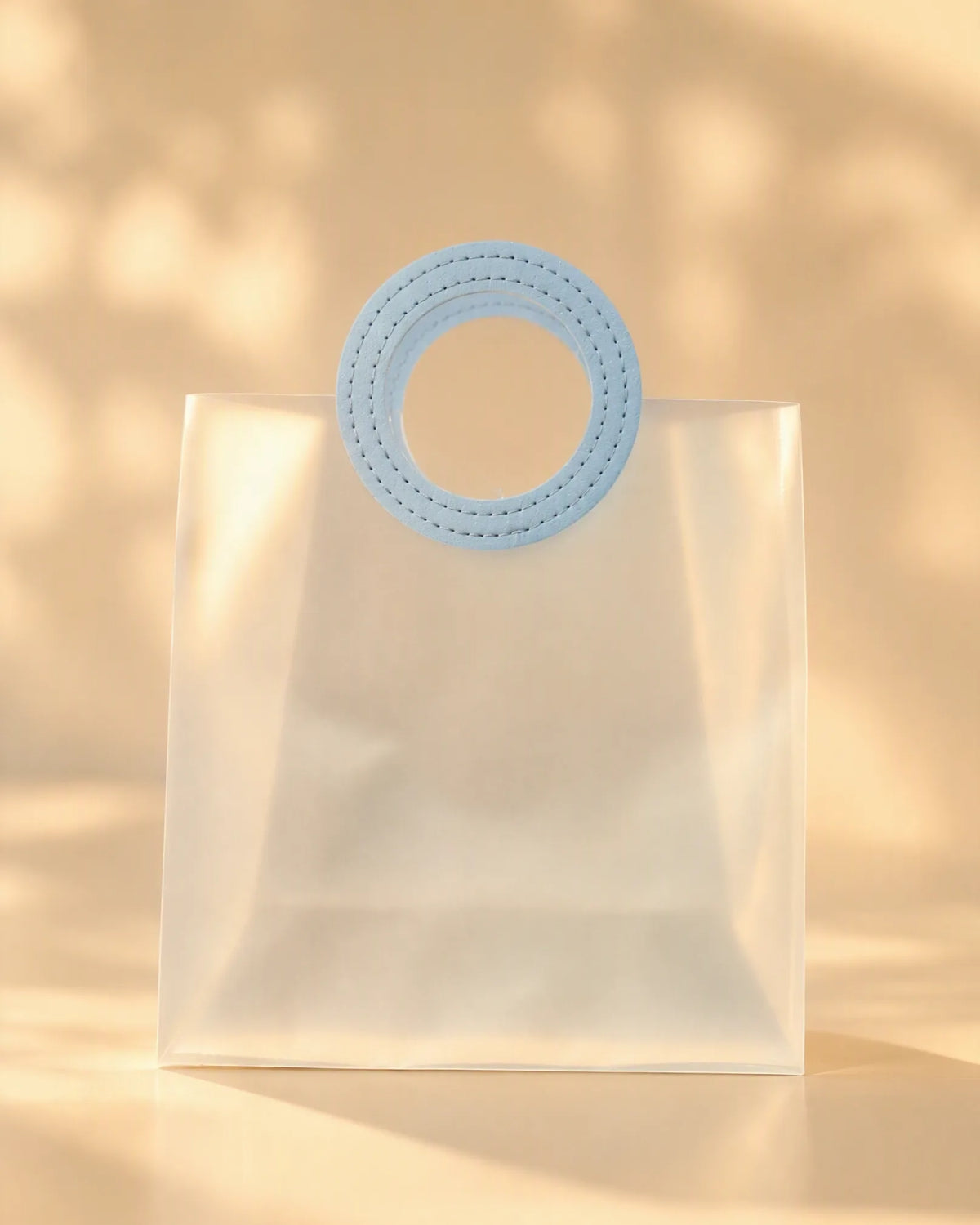 Translucent PVC tote bag with circular blue stitched handle