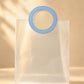 Frosted PVC gift bag with round blue handle, close front view