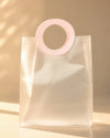 Clear PVC gift bag with pink round handle, full front view