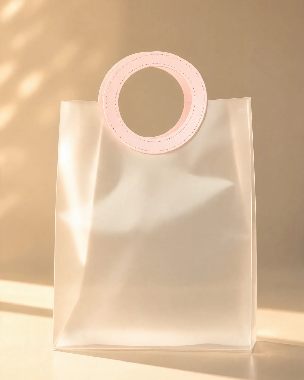 Clear PVC gift bag with pink round handle, full front view