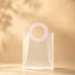Clear PVC gift bag with pink round handle, closer front view