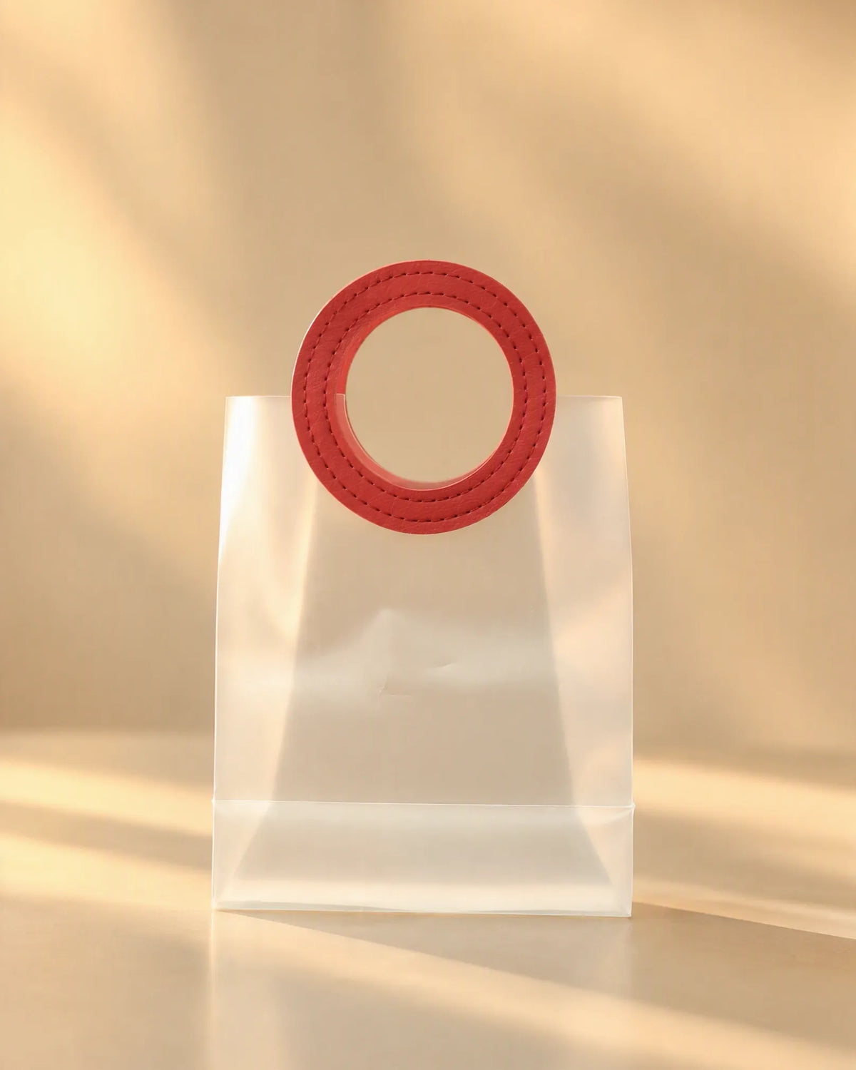 Clear PVC gift bag shown close-up, focused on the red round handle