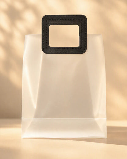 Frosted PVC gift bag with a stitched black square handle, front view