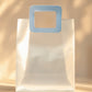 Clear PVC gift bag with a light blue square handle, closer front-on view