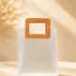Frosted PVC gift bag with tan square handle, straight-on view