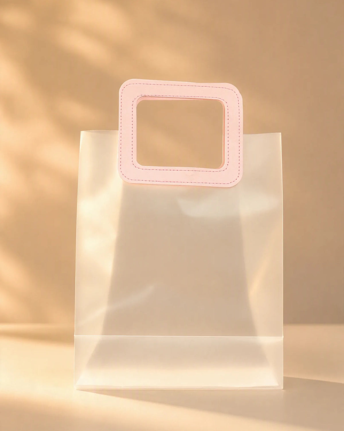 Clear PVC gift bag with pink square handle, size S, front view