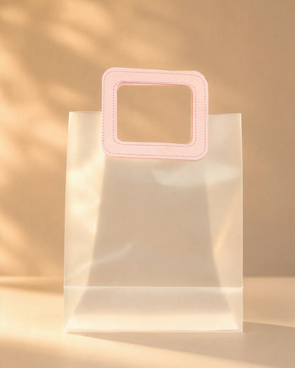 Clear PVC gift bag with pink square handle, size S, front view