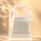 Clear PVC gift bag with pink square handle, size L, front view