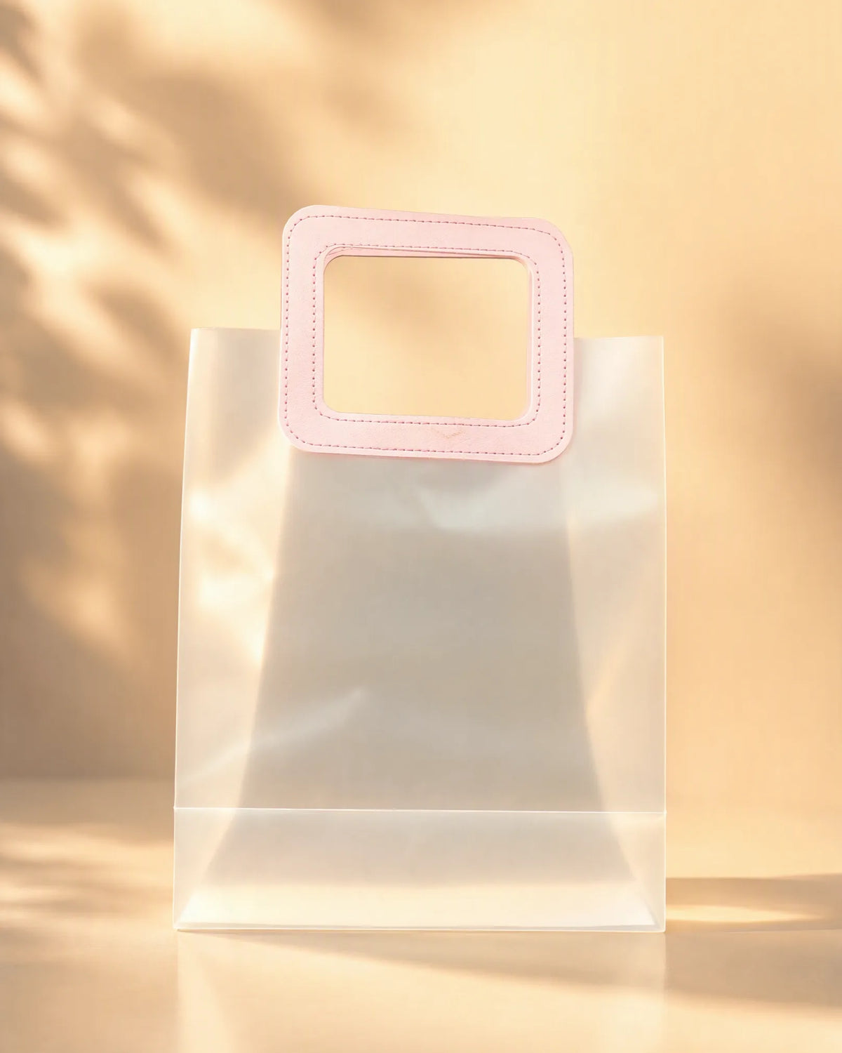 Clear PVC gift bag with pink square handle, size L, front view