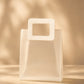 Translucent PVC gift bag with square carry handle, straight-on view