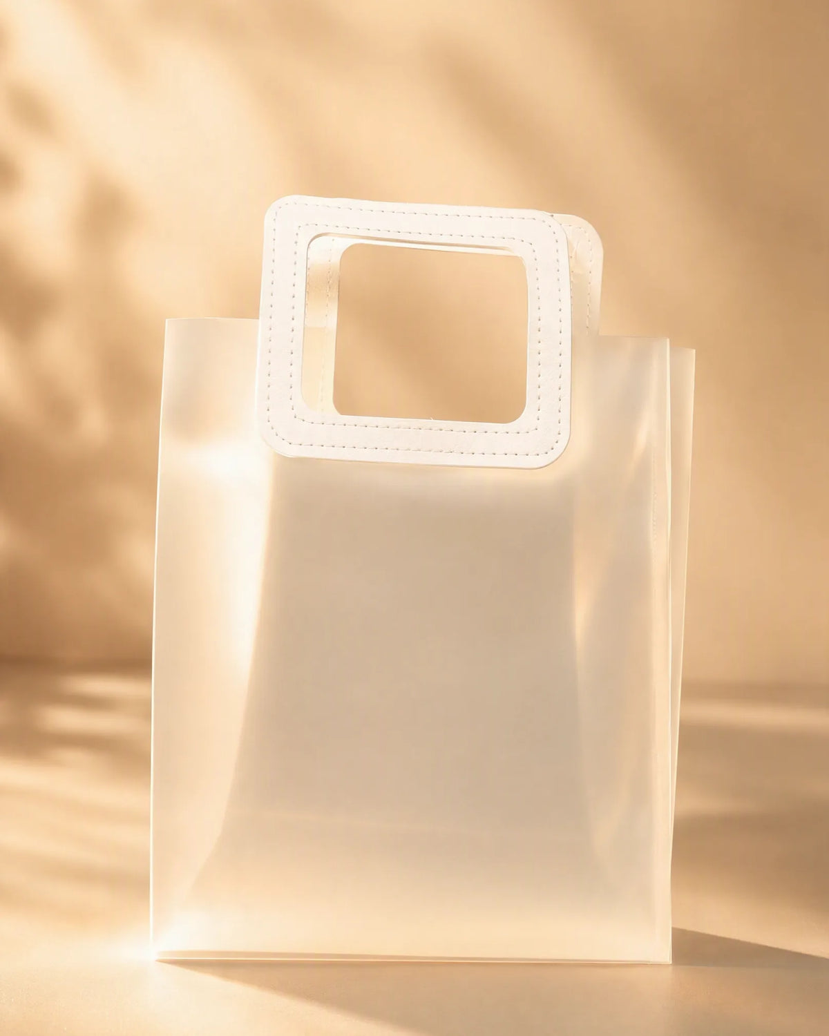 Frosted PVC gift bag with stitched square handle, close front view