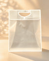 Frosted white PVC gift bag with cutout handle and button closure