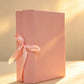 Pink rigid gift box with pink ribbon bow, closed upright