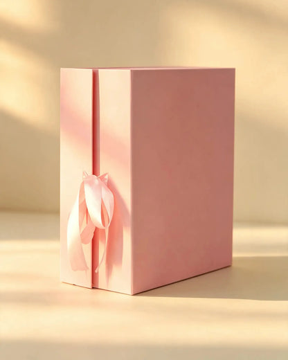 Pink rigid gift box with a pink satin ribbon bow, closed, front angle