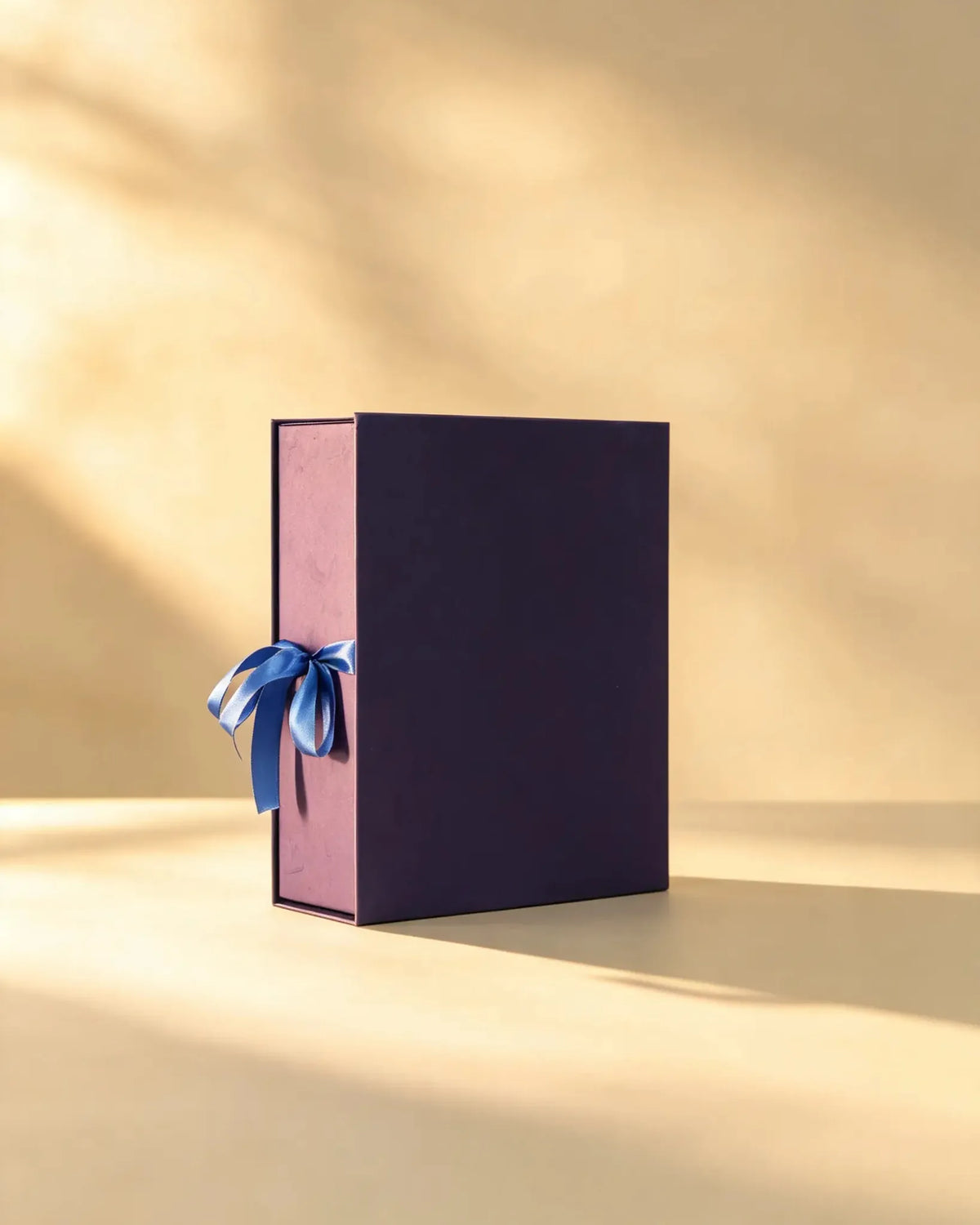 Deep plum gift box with mauve sides and blue satin ribbon bow