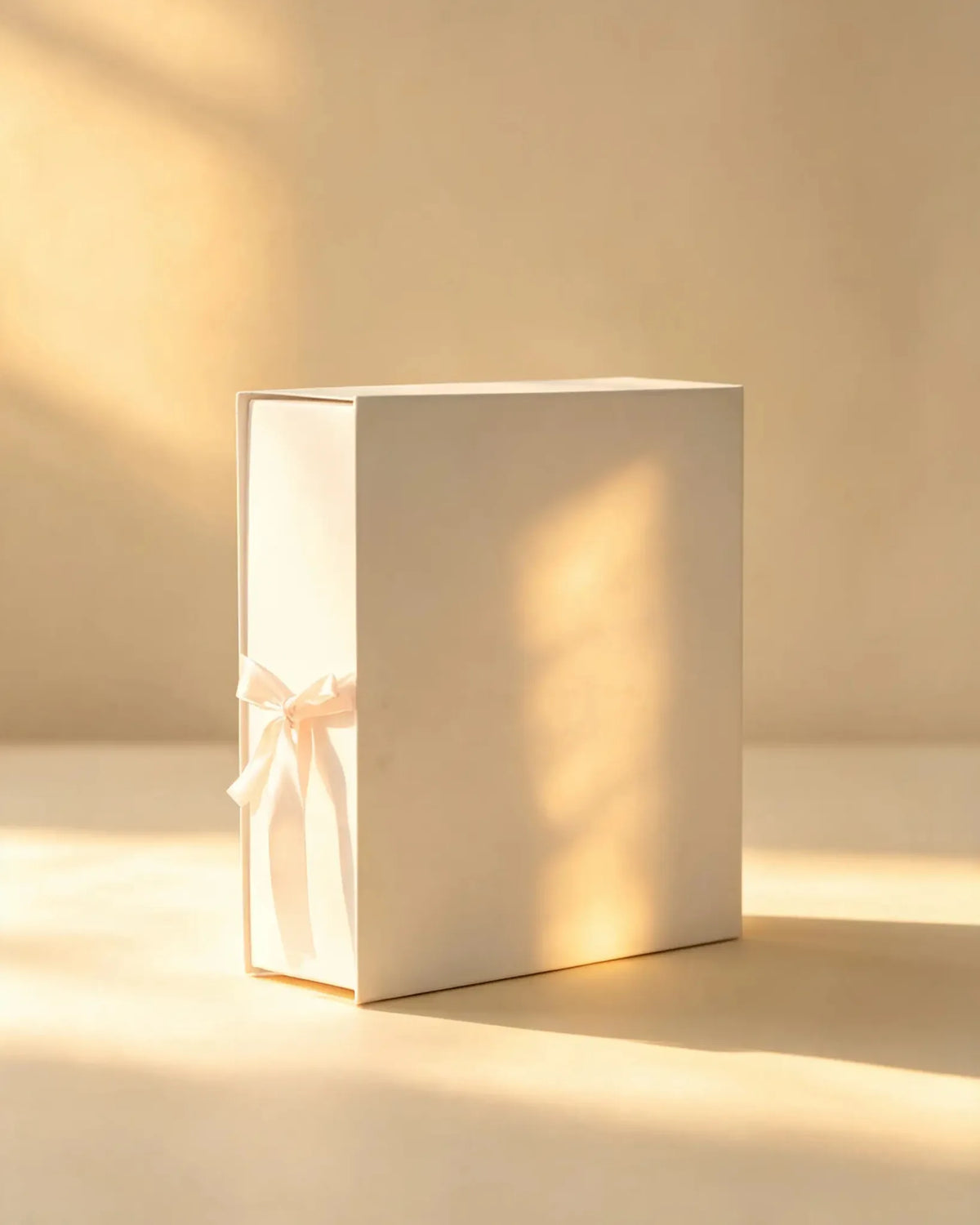 Ivory white gift box with matching ribbon bow, angled view