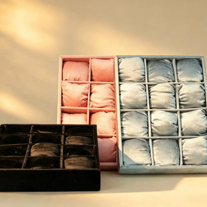 Pink and silver velvet bangle trays with cushioned compartments, plus a black tray in front